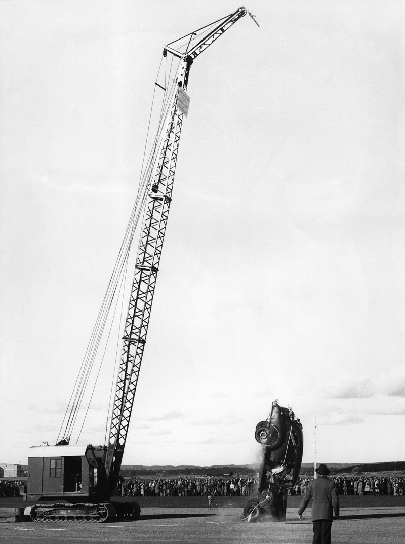 Crane lifting car during crash test.